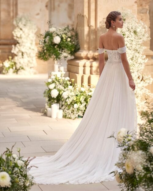 Vestido de novia con hombros descubiertos y falda con abertura delantera